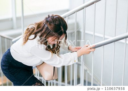 階段で腰痛に苦しむビジネスウーマン(ぎっくり腰・膠原病・関節リウマチ) 階段で腰痛に苦しむビジネスウーマン(ぎっくり腰・膠原病・関節リウマチ) 110637938