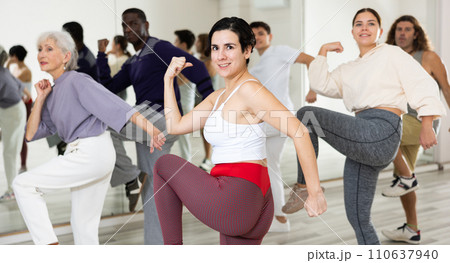 Cheerful young lady learning new modern dance in group dance lesson 110637940