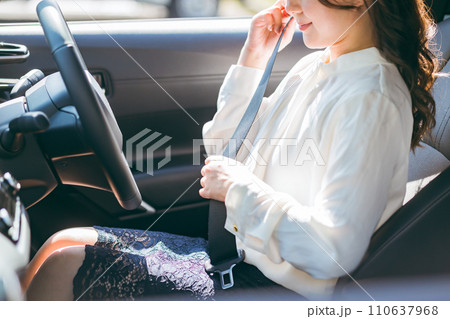 車に乗り込みシートベルトをする女性ドライバー（交通ルール・安全運転・交通安全） 110637968