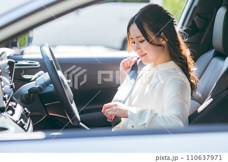 車に乗り込みシートベルトをする女性ドライバー（交通ルール・安全運転・交通安全） 110637971