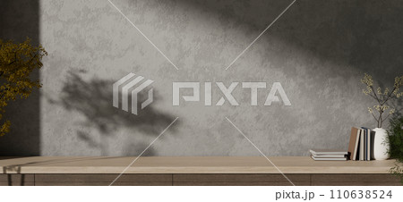 Empty copy space on a wooden tabletop against the cement loft wall with shadow and daylight indoors. 110638524