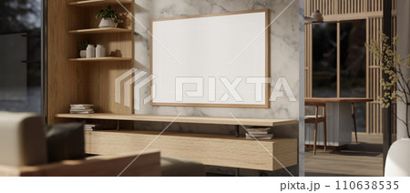 An empty white frame poster mockup on a marble wall in a modern, luxury and cosy living room. 110638535