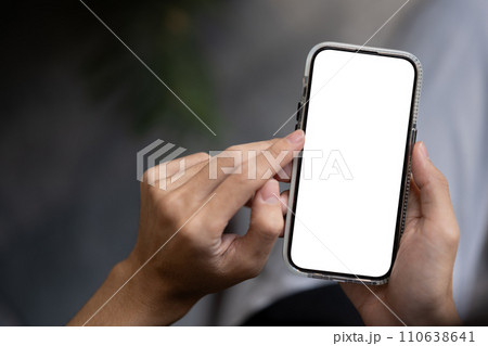 Close-up image of a man using his smartphone outdoors. A white-screen smartphone mockup. 110638641