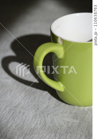 窓辺に置いた緑色のコーヒーカップ 110638763