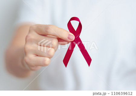 woman with Burgundy Red Ribbon for March multiple myeloma Cancer and December World Aids Day Awareness month. Healthcare and world cancer day concept 110639612