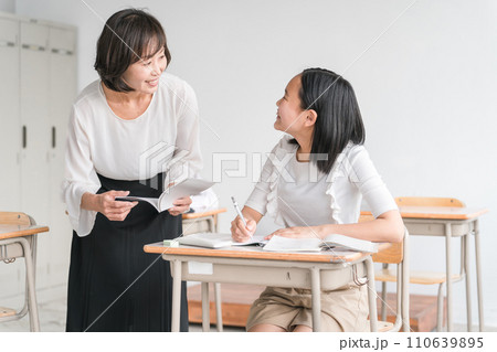 学校や塾で塾講師・先生に褒められてやる気になるアジア人の小学生・中学生・高校生の生徒(子供・女の子) 学校や塾で塾講師・先生に褒められてやる気になるアジア人の小学生・中学生・高校生の生徒(子供・女の子) 110639895