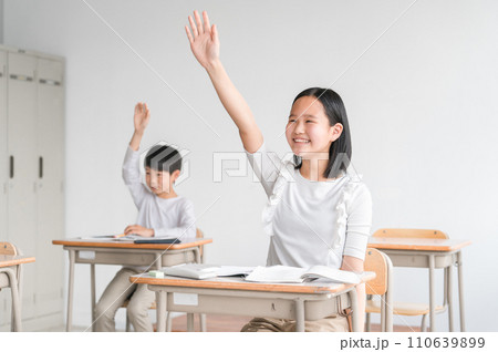 学校の教室・塾で授業中に手を上げる笑顔の小学生(夏期講習・挙手・勉強・学童・児童クラブ・学童保育) 学校の教室・塾で授業中に手を上げる笑顔の小学生(夏期講習・挙手・勉強・学童・児童クラブ・学童保育) 110639899