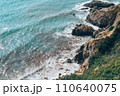 Large waves crash on the rocky shore view from above.  110640075