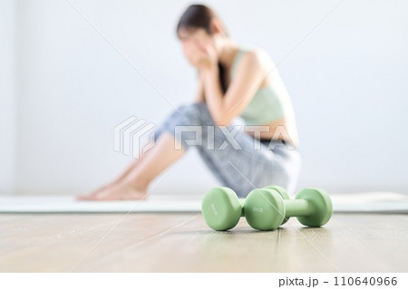 自宅トレーニングがうまく行かず落ち込む女性 110640966