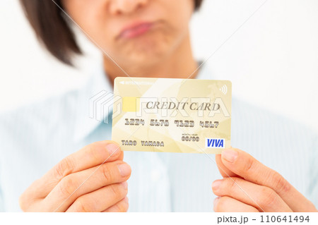 クレジットカードを持って悩むミドル女性 110641494