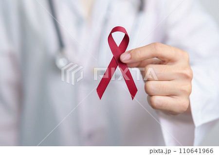 Doctor with Burgundy Red Ribbon for March multiple myeloma Cancer and December World Aids Day Awareness month. Healthcare and world cancer day concept 110641966