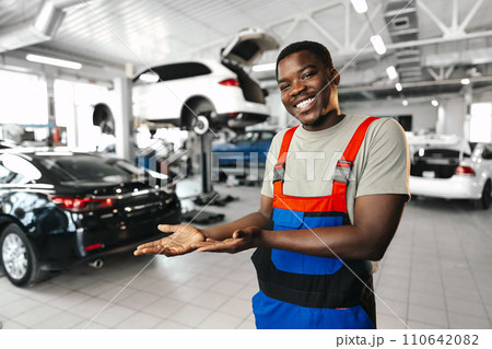 African man mechanic in uniform at the car repair station, portrait 110642082