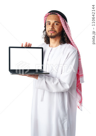 Arab man showing laptop wearing traditional clothes isolated on white 110642144