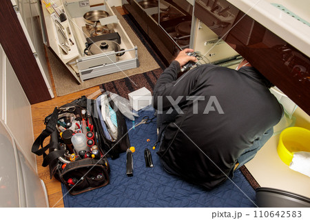 キッチン水栓の配管トラブルを修理する作業風景 110642583