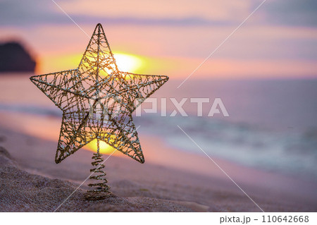 Golden christmas tree toy with big star on the beach Golden christmas tree toy with big star on the beach 110642668