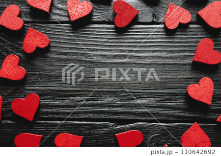 Red wooden hearts on black wooden background Red wooden hearts on black wooden background 110642692