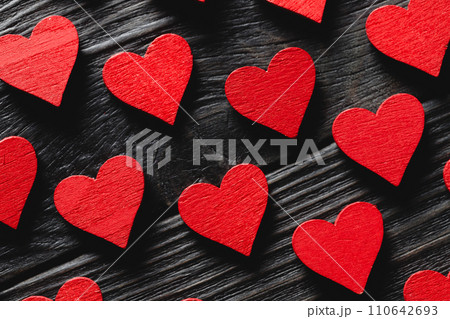 Red wooden hearts on black wooden background Red wooden hearts on black wooden background 110642693