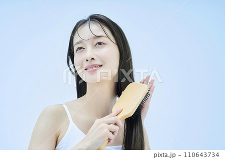 髪をブラッシングするロングヘアの女性 髪をブラッシングするロングヘアの女性 110643734