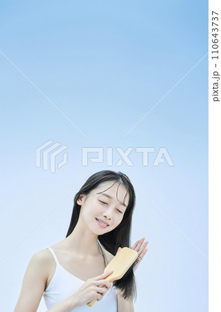 髪をブラッシングするロングヘアの女性 髪をブラッシングするロングヘアの女性 110643737