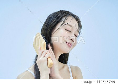 髪をブラッシングするロングヘアの女性 110643749