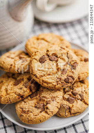 Sweet chocolate cookies on plate on checkered napkin. Sweet chocolate cookies on plate on checkered napkin. 110644347