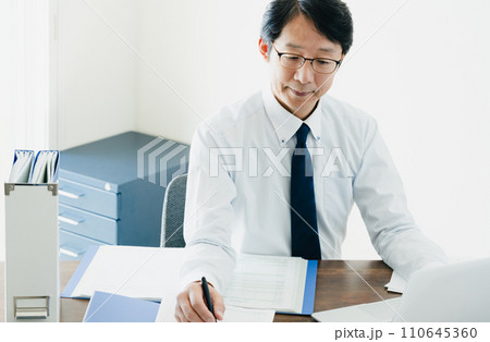 帳簿を確認する男性ビジネスマンの手元 110645360