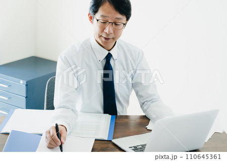 帳簿を確認する男性ビジネスマンの手元 帳簿を確認する男性ビジネスマンの手元 110645361