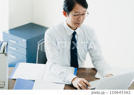 帳簿を確認する男性ビジネスマンの手元 110645362