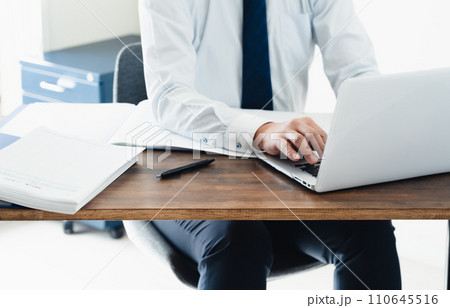 帳簿を確認する男性ビジネスマン 帳簿を確認する男性ビジネスマン 110645516