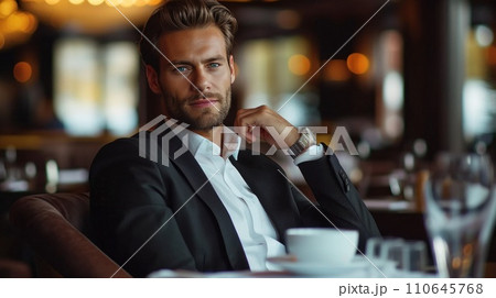 elegant business man sitting in luxury restaurant with glass of shampagne 110645768