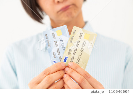 クレジットカードを持って悩むミドル女性 110646604