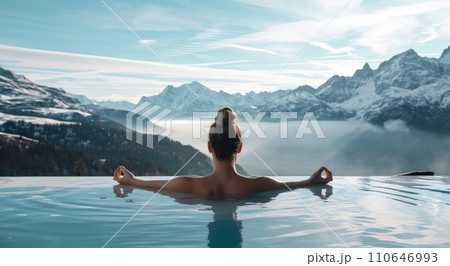woman in hot tub meditating with mountains in background 110646993