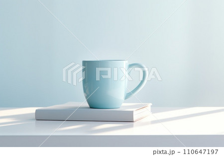 a cup of coffee is sitting atop a blue book on a saucer 110647197
