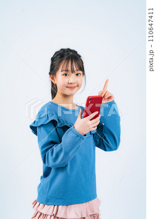 スマホを持って指さす女の子 110647411