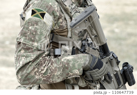 Soldier with assault rifle and flag of Jamaica on military uniform. Collage. 110647739