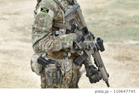 Soldier with assault rifle and flag of Jamaica on military uniform. Collage. Soldier with assault rifle and flag of Jamaica on military uniform. Collage. 110647745