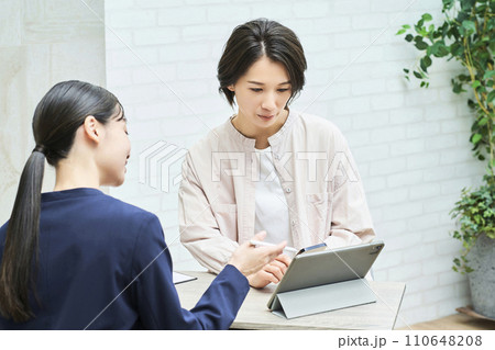 私服の女性に説明するスーツ姿の女性 110648208