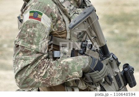 Soldier with assault rifle and flag of Ethiopia on military uniform. Collage. Soldier with assault rifle and flag of Ethiopia on military uniform. Collage. 110648594