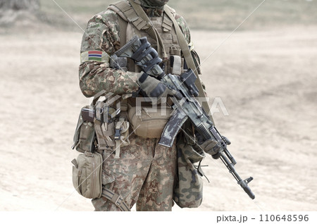 Soldier with assault rifle and flag of the Gambia on military uniform. Collage. 110648596