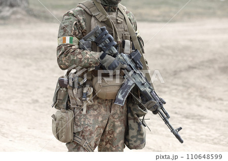 Soldier with assault rifle and flag of Ivory Coast or Cote d'Ivoire on military uniform. Collage. Soldier with assault rifle and flag of Ivory Coast or Cote d'Ivoire on military uniform. Collage. 110648599