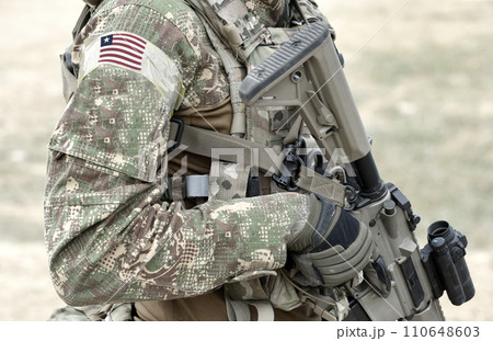 Soldier with assault rifle and flag of Liberia on military uniform. Collage. Soldier with assault rifle and flag of Liberia on military uniform. Collage. 110648603
