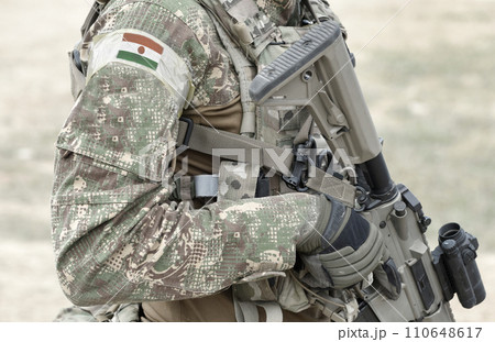 Soldier with machine gun and flag of Niger on military uniform. Collage. Soldier with machine gun and flag of Niger on military uniform. Collage. 110648617