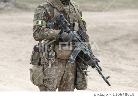 Soldier with machine gun and flag of Nigeria on military uniform. Collage. Soldier with machine gun and flag of Nigeria on military uniform. Collage. 110648619