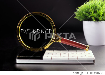 EVIDENCE text seen with a magnifying glass on a black background EVIDENCE text seen with a magnifying glass on a black background 110649022