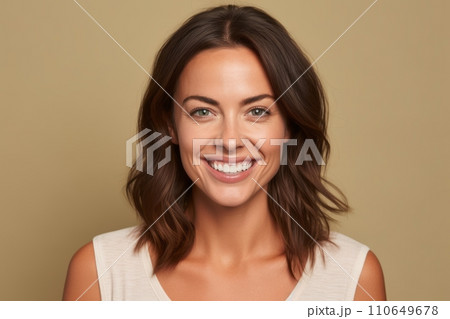 Portrait of beautiful young woman looking at camera and smiling, over beige background. 110649678