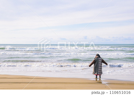 北陸地方・千里浜の浜辺で遊ぶ一人の女性 110651016