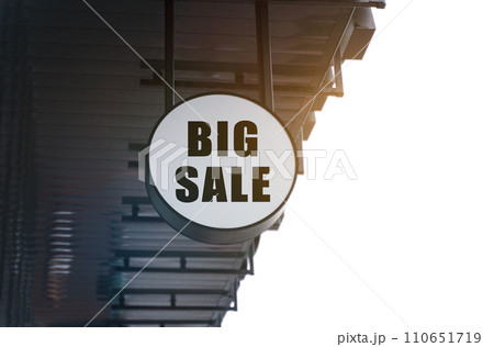 There is a circular sign under the roof of the building that says - BIG SALE There is a circular sign under the roof of the building that says - BIG SALE 110651719