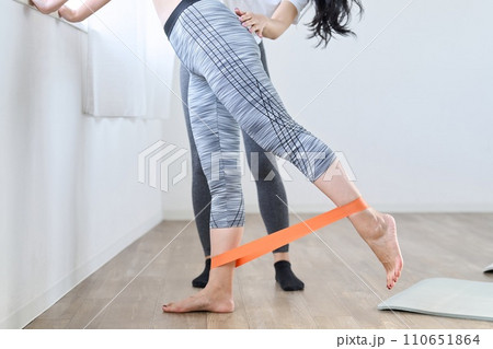 レジスタンスバンドを使って下半身のトレーニングをする女性 110651864