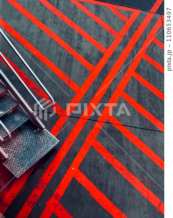 Vivid Red Lines on Asphalt with Metal Stairs Vivid Red Lines on Asphalt with Metal Stairs 110653497