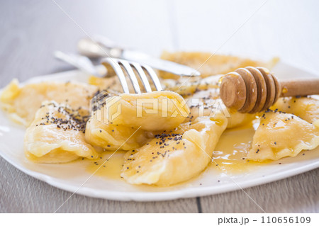 sweet cooked dumplings with cottage cheese, poppy seeds and honey. sweet cooked dumplings with cottage cheese, poppy seeds and honey. 110656109